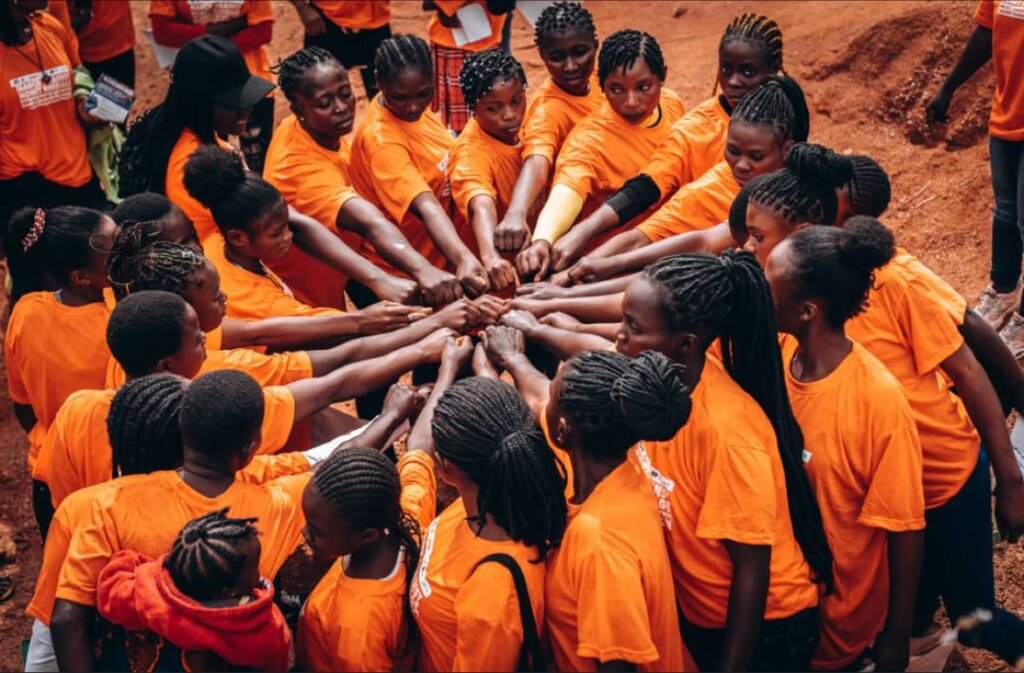 eenage mothers, survivors of money woman practice and at-risk girls at Her Voice Foundation have hands joined in solidarity.